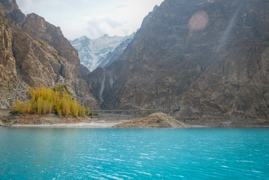 turquoise-water-attabad-lake-autumn-season-against-snow-capped-mountain-range